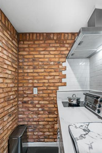 a kitchen with a brick wall and a stove at Mile to Beach! Tiki Master Suite in Oceanside