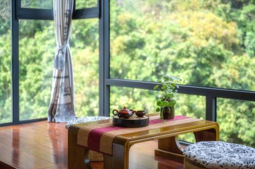 a table with a potted plant on it next to a window at Leisure Courtyard Hotel Yangshuo in Yangshuo