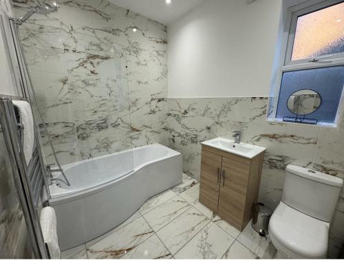 uma casa de banho com uma banheira, um WC e um lavatório. em Large NEW House, Sleeps 10, FREE Parking, Near City Centre em Liverpool