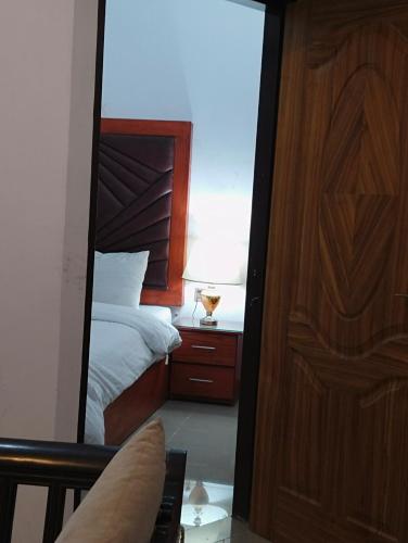 a mirror reflection of a bedroom with a bed at Homewood Suites Family Guest House & Apartments in Lahore