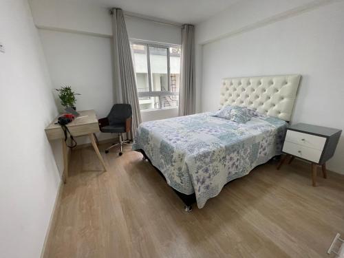 Un dormitorio con una cama y un escritorio y una ventana. en Nuevo Departamento en CentroHistórico de Arequipa, en Arequipa