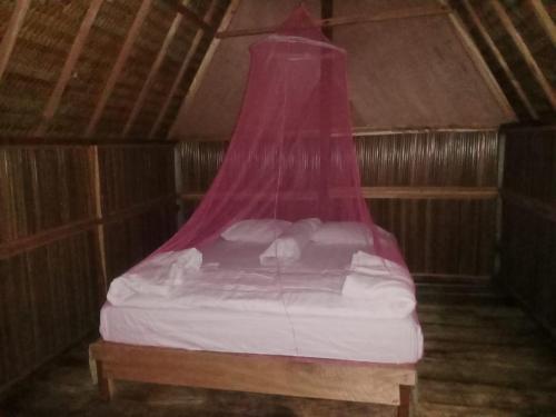 łóżko z różowym baldachimem w pokoju w obiekcie Or Mandira Guest House w mieście Fam