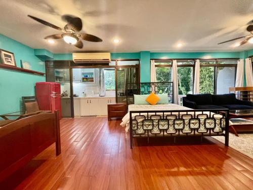 a living room with a couch and a ceiling fan at Ngermid Oasis-XL Studio With Kitchen & Scenic Views in Koror