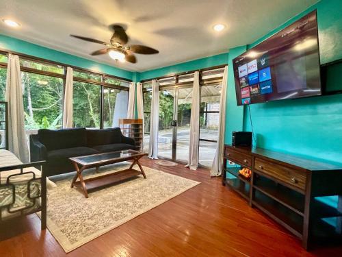 a living room with a couch and a flat screen tv at Ngermid Oasis-XL Studio With Kitchen & Scenic Views in Koror