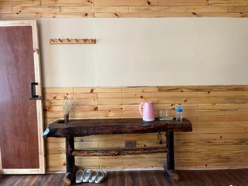 Cette chambre est dotée d'un mur en bois et d'une table en bois. dans l'établissement Hotel Namche, à Nāmche Bāzār