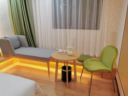 a room with a bed and a table and chairs at Connar Hotel - Shenzhen Futian in Shenzhen