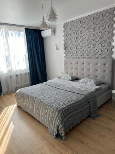 1 dormitorio con 1 cama grande y cabecero grande en VIP квартира в центре города, новостойка в ЖК Prestige Apаrtments, Ровно, en Rivne