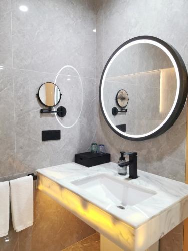 a bathroom with a sink and a mirror at Connar Hotel - Shenzhen Futian in Shenzhen