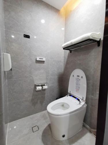a bathroom with a white toilet in a stall at Connar Hotel - Shenzhen Futian in Shenzhen