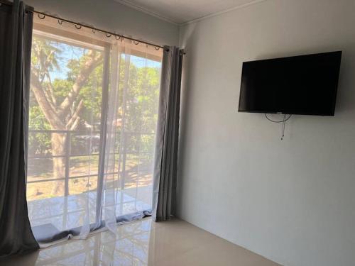 um quarto com uma grande janela e uma televisão de ecrã plano em Apartamento cerca de Tamarindo em Villarreal