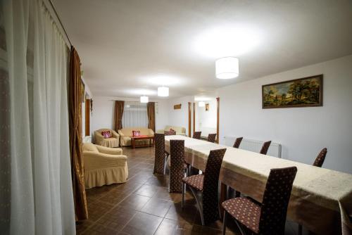 a dining room with a long table and chairs at Cabana Georgiana in Arieşeni