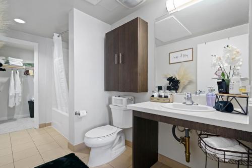 Łazienka z białą toaletą i umywalką w obiekcie DTLA Escape Skyline views with luxury amenities w Los Angeles