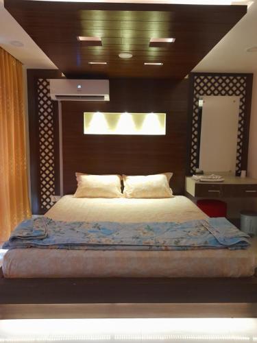 Schlafzimmer mit einem großen Bett mit einem Kopfteil aus Holz in der Unterkunft York Air B and B in Kathmandu