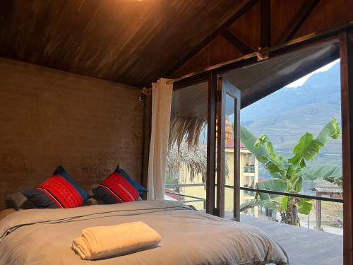 a bedroom with a bed and a large window at Sa Moc & La Maison SAPA - Bungalows in Sa Pa