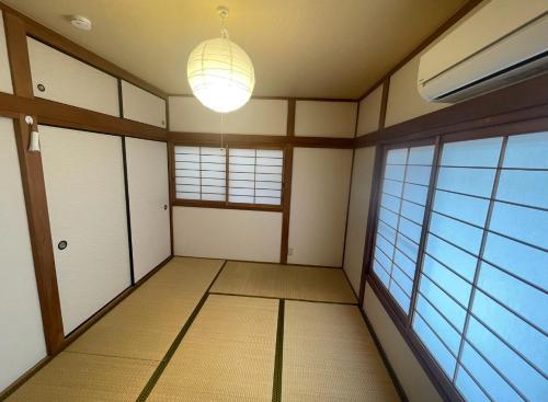 ZY House في أوساكا: غرفة فارغة مع نافذة كبيرة ومصباح