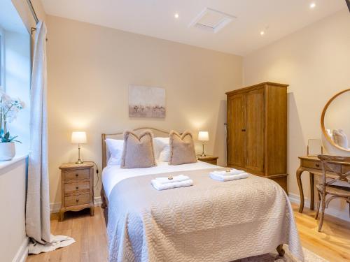 1 dormitorio con 1 cama con 2 toallas en Rose Cottage - Uk45497 