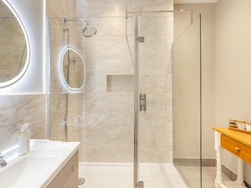 a bathroom with a shower with a glass door at Rose Cottage - Uk45497 