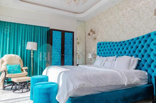 a blue bedroom with a large bed and a chair at Grandeur 3 Bedroom In Wave in Abu Dhabi