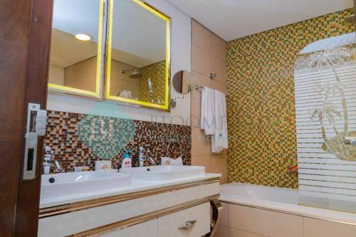 a bathroom with a sink and a mirror at Grandeur 3 Bedroom In Wave in Abu Dhabi