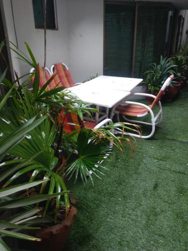 a table and chairs and plants in a courtyard at Homewood Suites Family Guest House & Apartments in Lahore