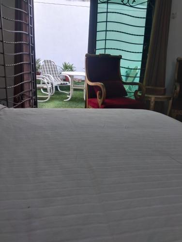 a bedroom with a bed and a patio with chairs at Homewood Suites Family Guest House & Apartments in Lahore