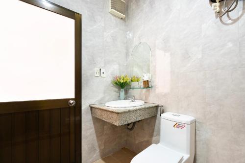La salle de bains est pourvue de toilettes blanches et d'un lavabo. dans l'établissement Planet Homestay, à Hô-Chi-Minh-Ville