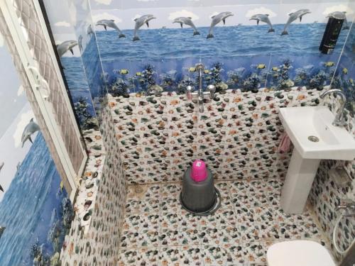 un baño con una bandada de aves volando sobre el océano en Bhavyam HomeStay &Cafe BackPackers ko, en Bundi