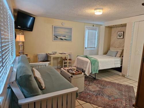 Coral Resort D4 في كليرووتر بيتش: غرفة صغيرة بها سرير وغرفة بها أريكة