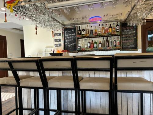 a bar with stools in front of a counter with bottles of alcohol at ViaVia Boutique Hotel - Kathmandu in Kathmandu