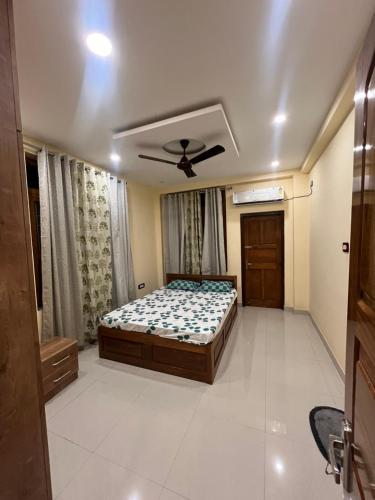 a bedroom with a bed and a ceiling fan at Shrinath Palace in Deoghar