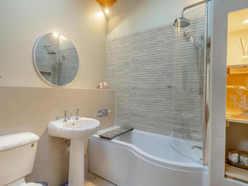 a bathroom with a sink and a tub and a toilet at Garden Cottage - Uk45498 