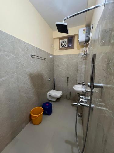 a bathroom with a shower and a sink and a toilet at Shrinath Palace in Deoghar