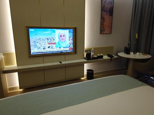a hotel room with a television on a wall at H Luxury Hotel in Wadi Musa