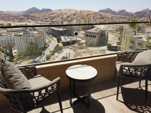 a balcony with two chairs and a view of a city at H Luxury Hotel in Wadi Musa