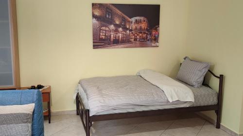 a bed in a room with a picture on the wall at Γκαρσονιέρα "Ελευθερία" Παλιά πόλη in Xanthi