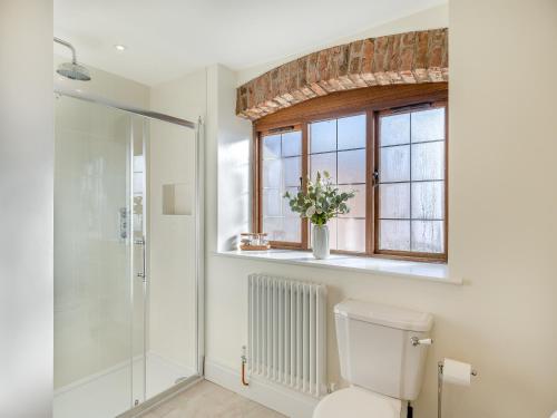 bagno con servizi igienici e finestra. di Eaton Barn - Uk45499 