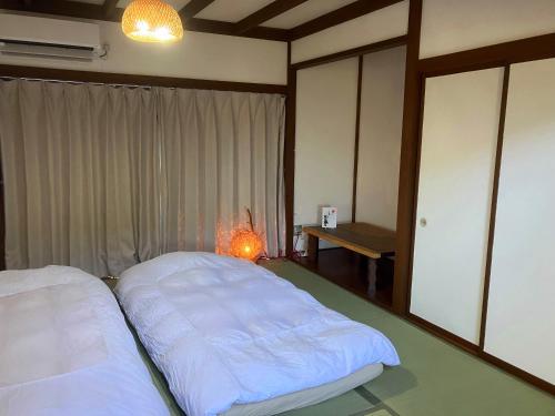 a bedroom with two beds and a lamp in it at 南箱根 熱海 貸切別荘 リゾートハウス トモ in Atami