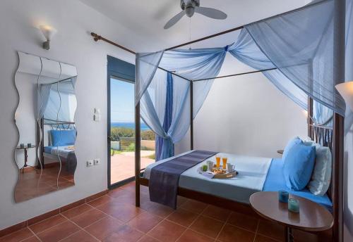 Schlafzimmer mit einem Bett und Meerblick in der Unterkunft Cristelia seafront & pool villa in Lachania