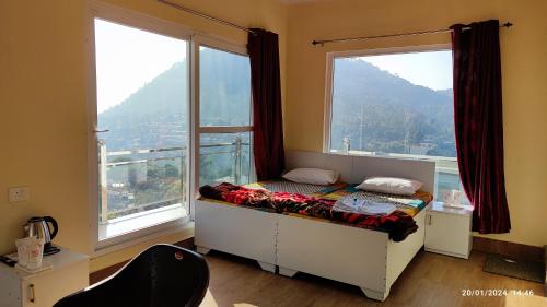 a bedroom with a bed in front of a window at Host Labs Homestay - Premium View - Close to Kaichi Dham, Bhimtal, Sattal, and more in Bhīm Tāl