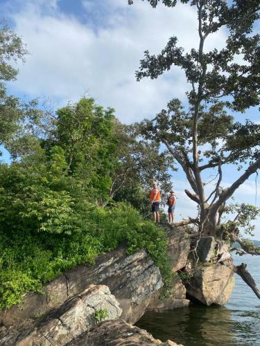 two people standing on top of a rock near the water at Mount View in Polonnaruwa