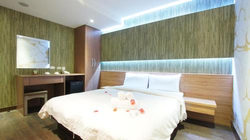 a bedroom with a large white bed with towels on it at Colors Infinity Inn in Taipei