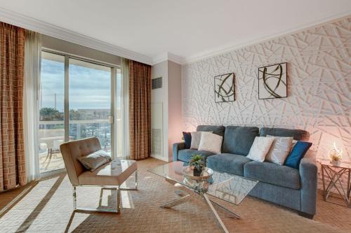 a living room with a blue couch and a glass table at Serenity Suite at MGM Signature in Las Vegas