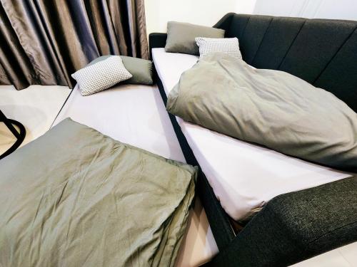 2 Betten nebeneinander auf einer Couch in der Unterkunft Kozi Square Twin Room with free Wi-fi & Carpark in Kuching