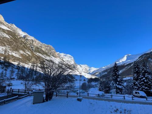 a view of a snowy mountain with a van parked at Les Barmettes Appart rénové avec vue, parking et skis aux pieds in Val-d'Isère