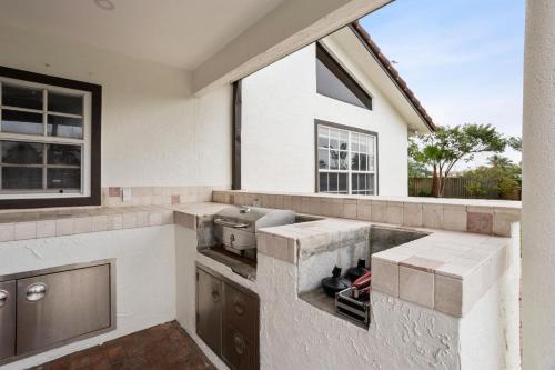 an outdoor kitchen with a stove and a window at Escondida Drive in West Palm Beach