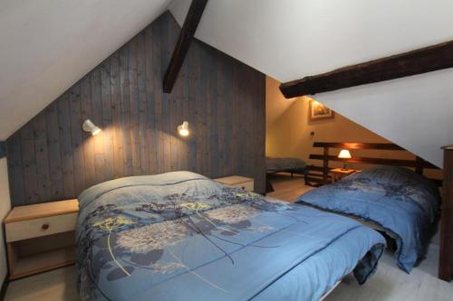 - une chambre mansardée avec un lit bleu dans l'établissement Sagette, à Laruns