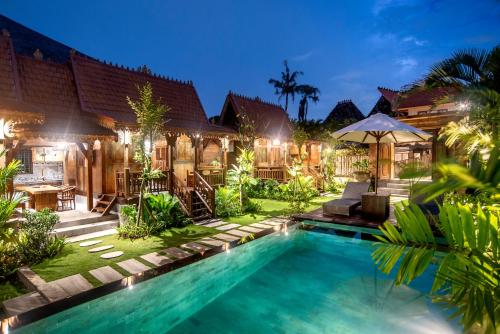 a villa with a swimming pool at night at PNB Bali Villas in Canggu