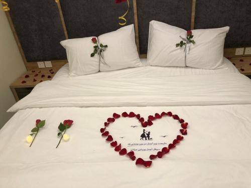 a heart on a bed with roses on it at بنزرت للشقق المخدومة in Al Hofuf