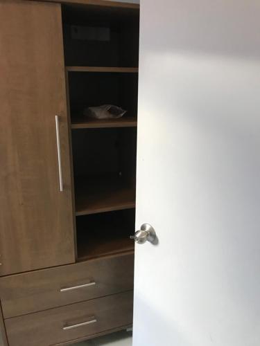 a closet with a white door and a wooden cabinet at Sweet Montreal room in Montreal