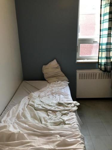 ein unmaskiertes Bett in einem Zimmer mit Fenster in der Unterkunft Sweet Montreal room in Montreal